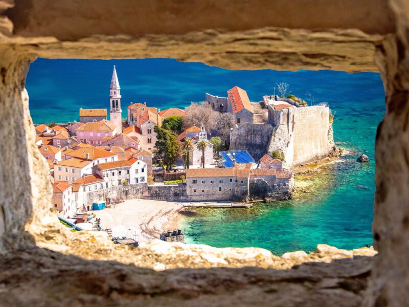 Historic,Town,Of,Budva,Architecture,And,Beach,View,Through,Stone